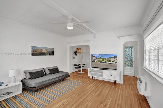 living room with hardwood / wood-style flooring, ceiling fan, crown molding, and a wall unit AC