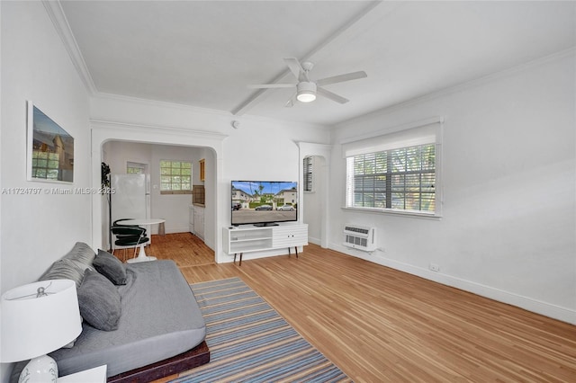 living room with heating unit, a wall mounted AC, ornamental molding, ceiling fan, and light hardwood / wood-style flooring