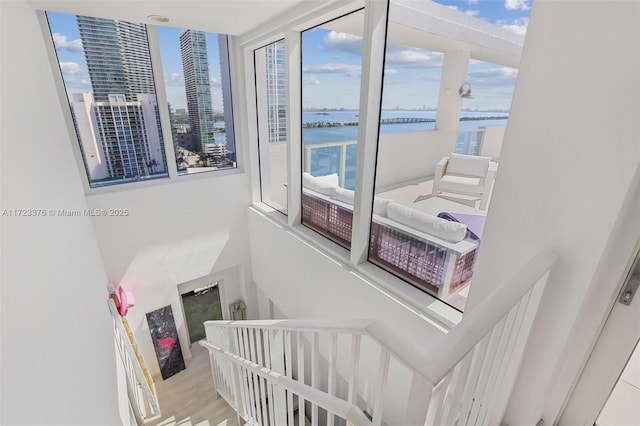 stairway featuring plenty of natural light, a water view, and wood finished floors