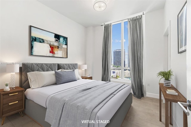 bedroom featuring light wood-type flooring and baseboards