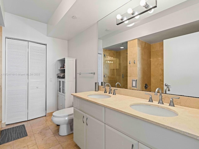 bathroom with toilet, a stall shower, a sink, and a closet
