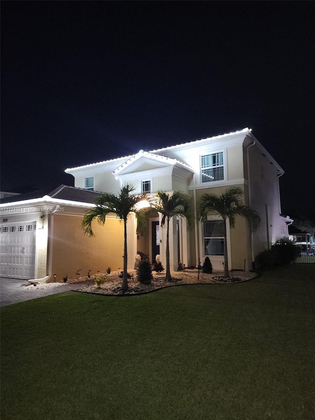 view of front of property featuring a garage and a lawn