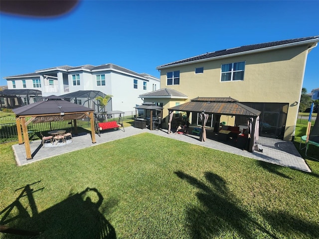 back of property with an outdoor hangout area, a gazebo, a lawn, and a patio