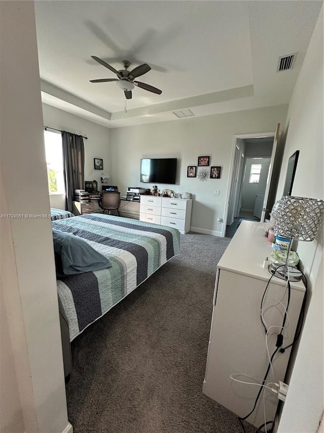 bedroom with carpet, ceiling fan, and a tray ceiling