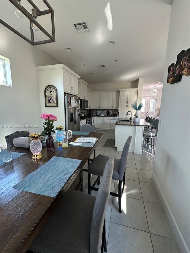 dining area with light tile patterned flooring, sink, and a healthy amount of sunlight