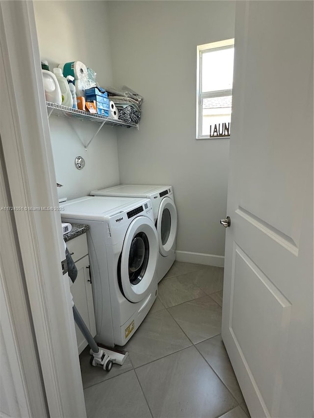 laundry room featuring cabinets, washer and clothes dryer, and light tile patterned floors