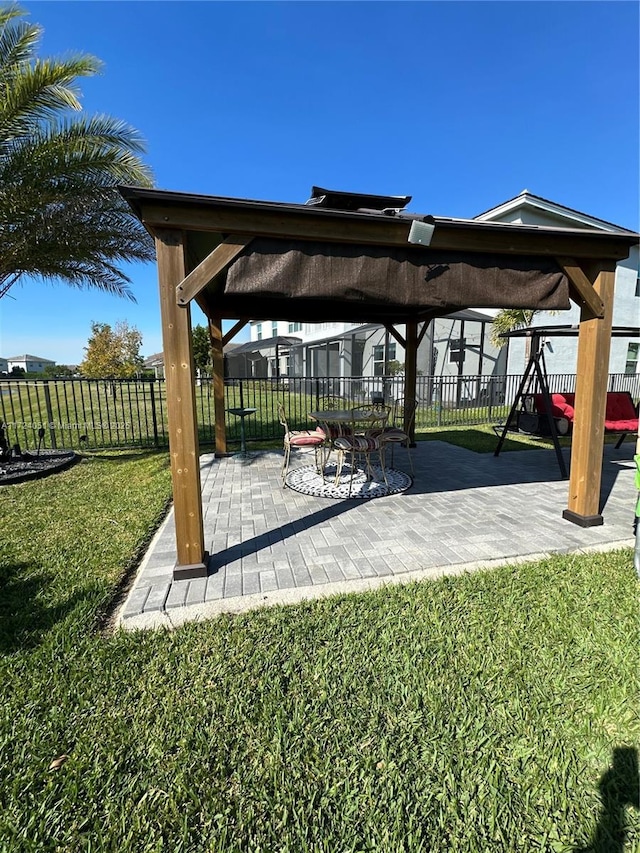 view of property's community featuring a gazebo, a playground, a patio area, and a lawn