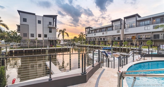 exterior space with a community pool and a water view