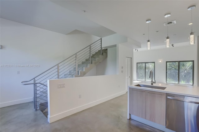 kitchen with pendant lighting, sink, concrete flooring, and dishwasher