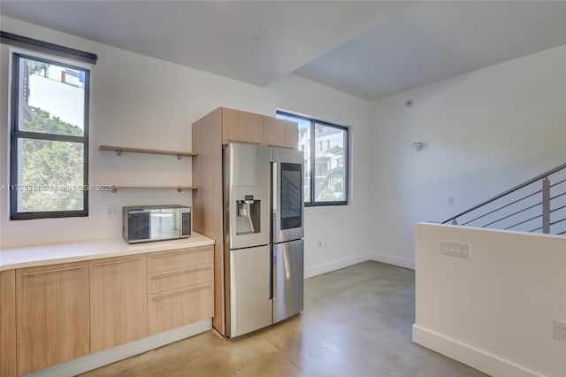 kitchen featuring stainless steel appliances and light brown cabinets