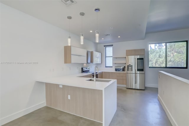 kitchen with sink, appliances with stainless steel finishes, hanging light fixtures, kitchen peninsula, and light brown cabinets