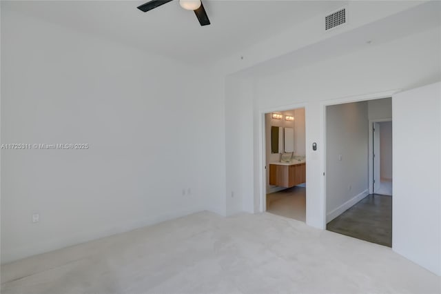 unfurnished bedroom featuring ceiling fan and ensuite bathroom