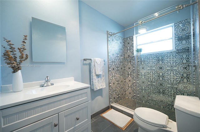 full bathroom featuring vanity, tile patterned flooring, a tile shower, and toilet