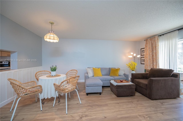 living room featuring a textured ceiling and light hardwood / wood-style floors