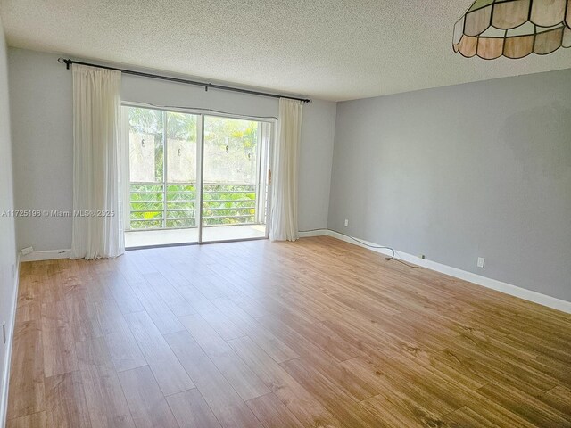 1000 NE 14th Ave Unit 404, Hallandale Beach, FL 33009 - unfurnished room featuring a textured ceiling, light wood-type flooring, and baseboards