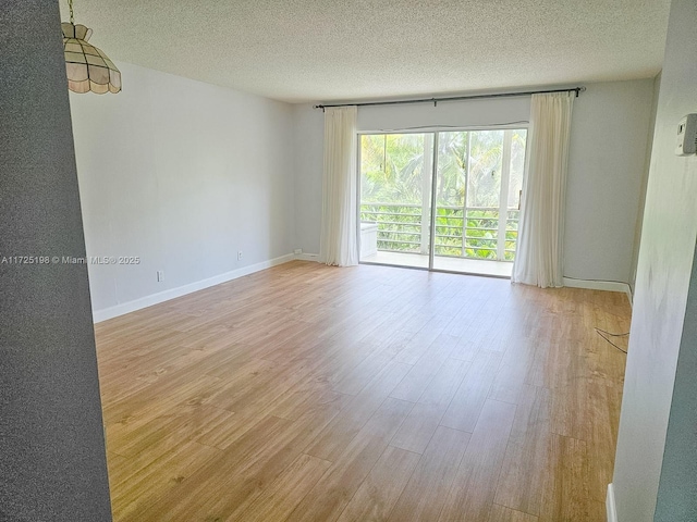 1000 NE 14th Ave Unit 404, Hallandale Beach, FL 33009 - spare room with wood finished floors, a textured ceiling, and baseboards