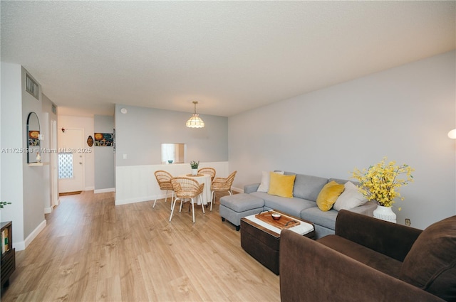 living room with a textured ceiling and light wood-type flooring