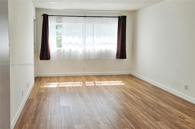 1000 NE 14th Ave Unit 404, Hallandale Beach, FL 33009 - unfurnished room featuring wood finished floors, baseboards, and a textured ceiling
