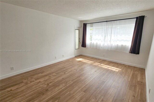 1000 NE 14th Ave Unit 404, Hallandale Beach, FL 33009 - spare room featuring wood finished floors, a textured ceiling, and baseboards