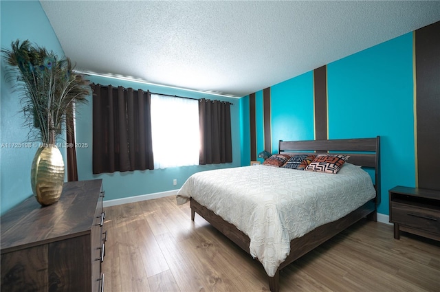 bedroom with hardwood / wood-style flooring and a textured ceiling