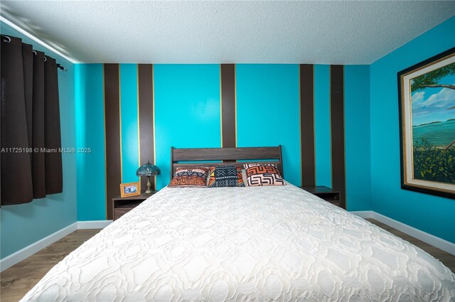 bedroom with hardwood / wood-style flooring and a textured ceiling