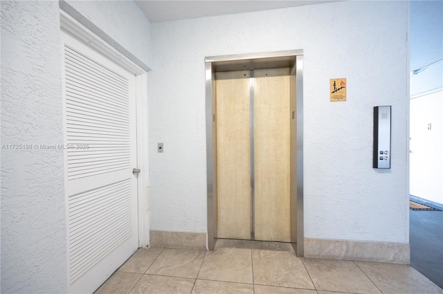 1000 NE 14th Ave Unit 404, Hallandale Beach, FL 33009 - hall featuring a textured wall, elevator, and tile patterned floors