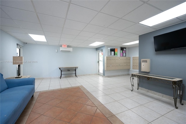 living room with a drop ceiling, an AC wall unit, and light tile patterned floors