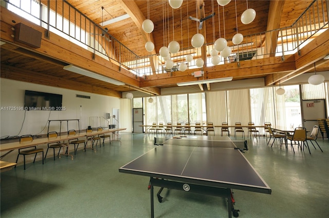 recreation room with a towering ceiling, wooden ceiling, a wealth of natural light, and beam ceiling