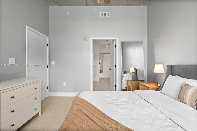 bedroom featuring connected bathroom and light wood-type flooring