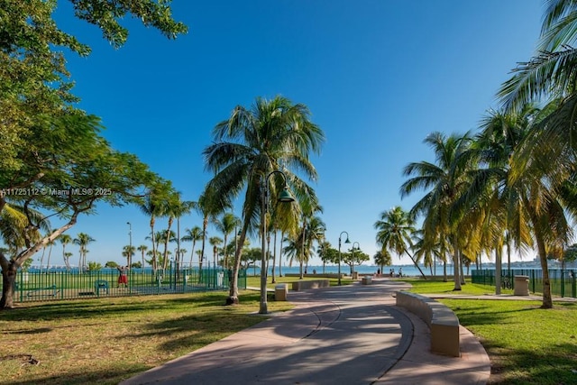 view of home's community with a water view and a lawn