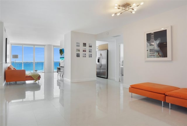 corridor with floor to ceiling windows, a water view, an inviting chandelier, and light tile patterned floors