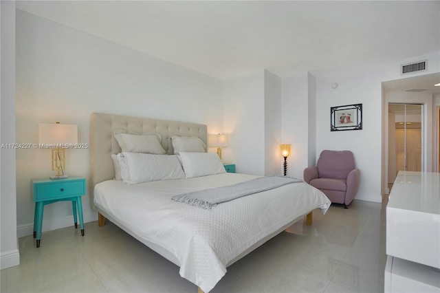 bedroom featuring a walk in closet and light tile patterned flooring