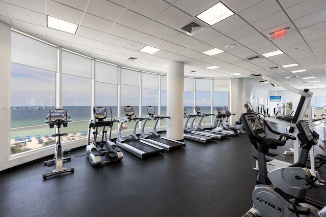 exercise room featuring a paneled ceiling and a water view