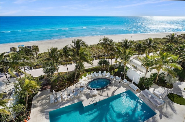 birds eye view of property featuring a beach view and a water view