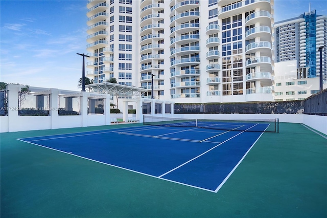 view of tennis court with basketball hoop