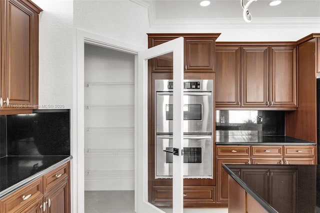 kitchen with double oven, ornamental molding, and tasteful backsplash