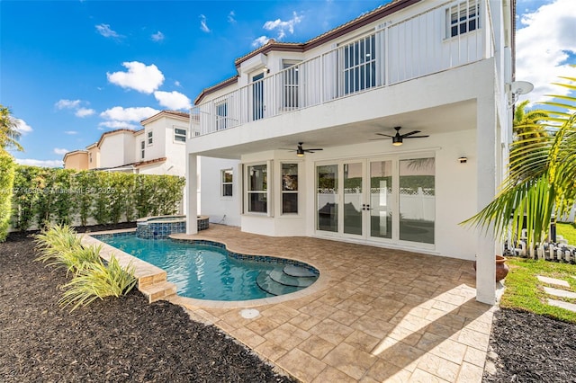 rear view of house featuring a balcony, a patio, french doors, ceiling fan, and a pool with hot tub