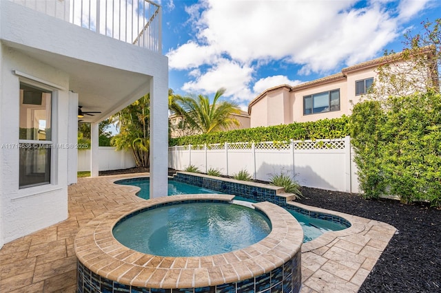 view of swimming pool with a patio area, ceiling fan, and an in ground hot tub