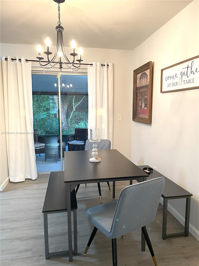 dining area featuring an inviting chandelier and hardwood / wood-style flooring