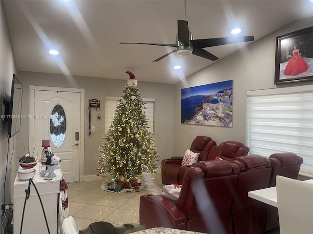 living room with lofted ceiling, ceiling fan, and light tile patterned floors