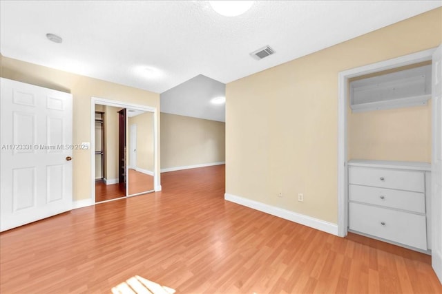 empty room featuring a textured ceiling and light hardwood / wood-style flooring