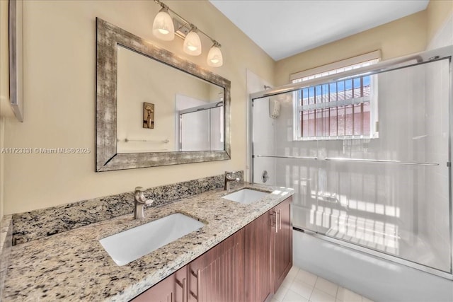 bathroom with vanity, tile patterned flooring, and bath / shower combo with glass door