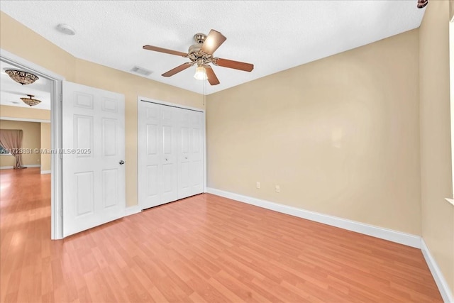 unfurnished bedroom with hardwood / wood-style floors, a textured ceiling, and ceiling fan