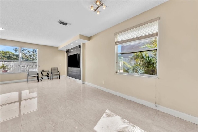 empty room with a notable chandelier and light tile patterned floors