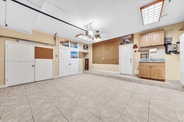 garage with ceiling fan, sink, and a garage door opener