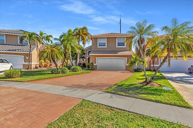 mediterranean / spanish home featuring a front yard and a garage