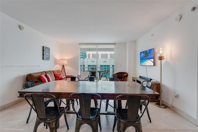 dining room featuring floor to ceiling windows and light tile patterned floors