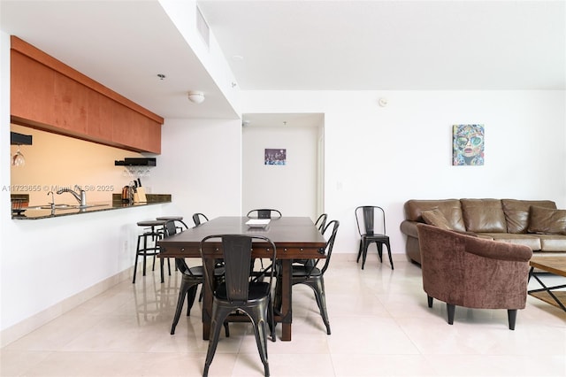 dining area featuring sink and light tile patterned floors