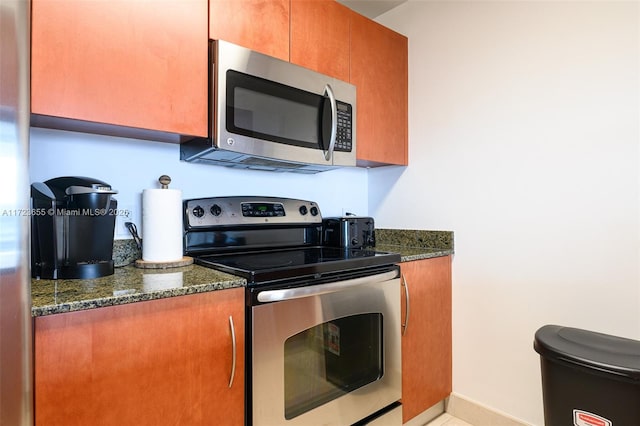 kitchen with stainless steel appliances and dark stone countertops