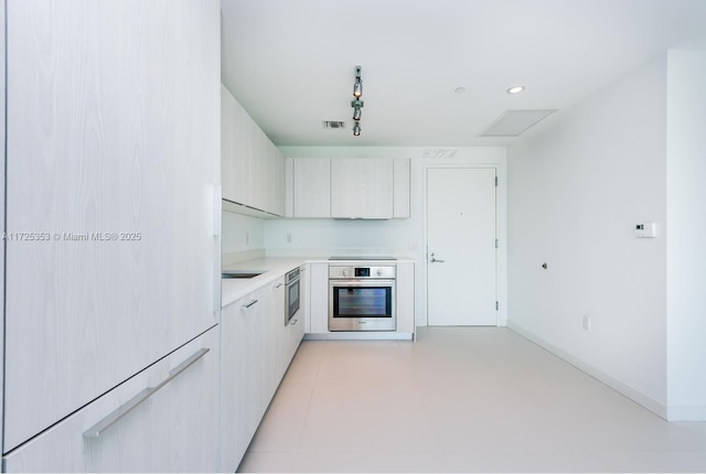 kitchen featuring stainless steel oven, track lighting, and black electric stovetop